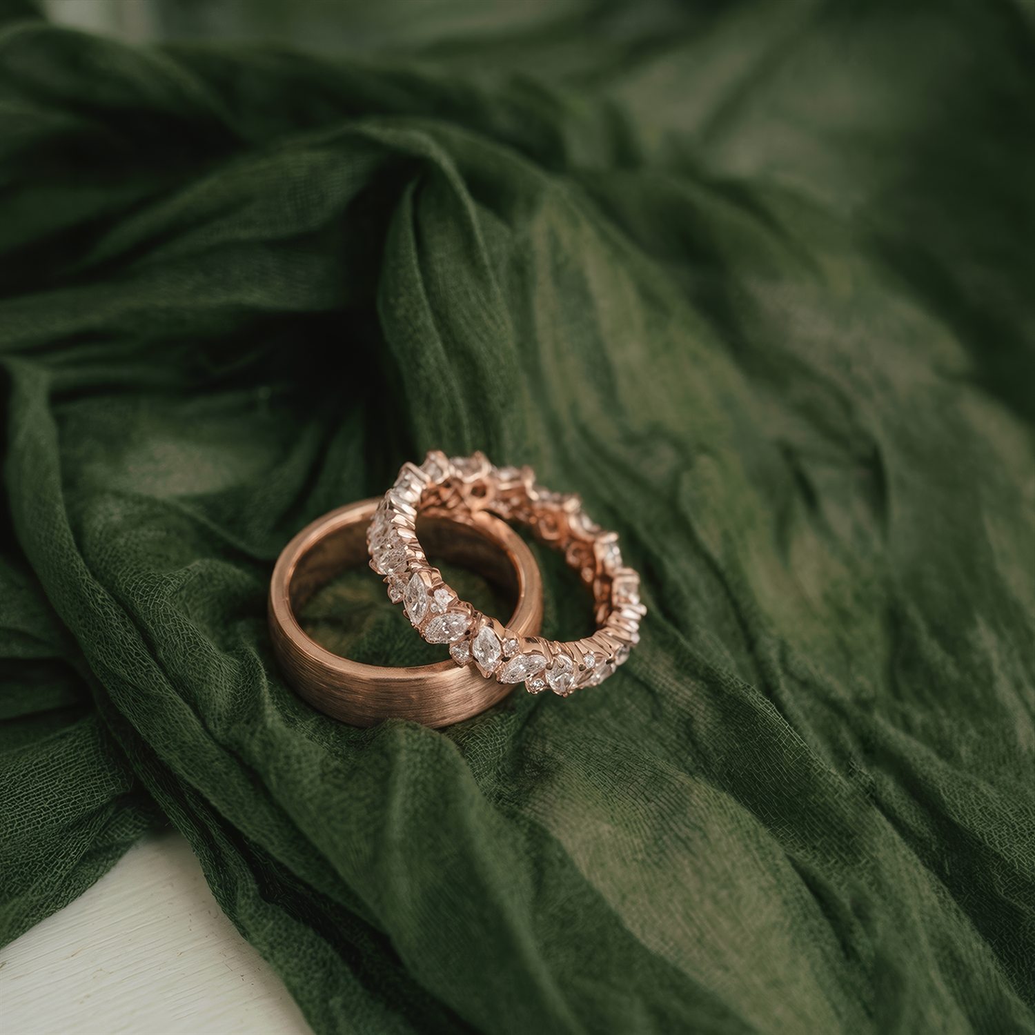 Cặp nhẫn cưới ThreeTrees, vàng hồng 18K, đính kim cương trên nền lụa xanh rêu